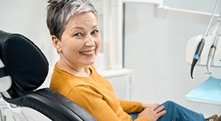 Happy middle-aged dental patient looking over her shoulder