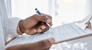 Doctor holding clipboard, filling out form