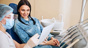 Dental team member discussing paperwork with patient