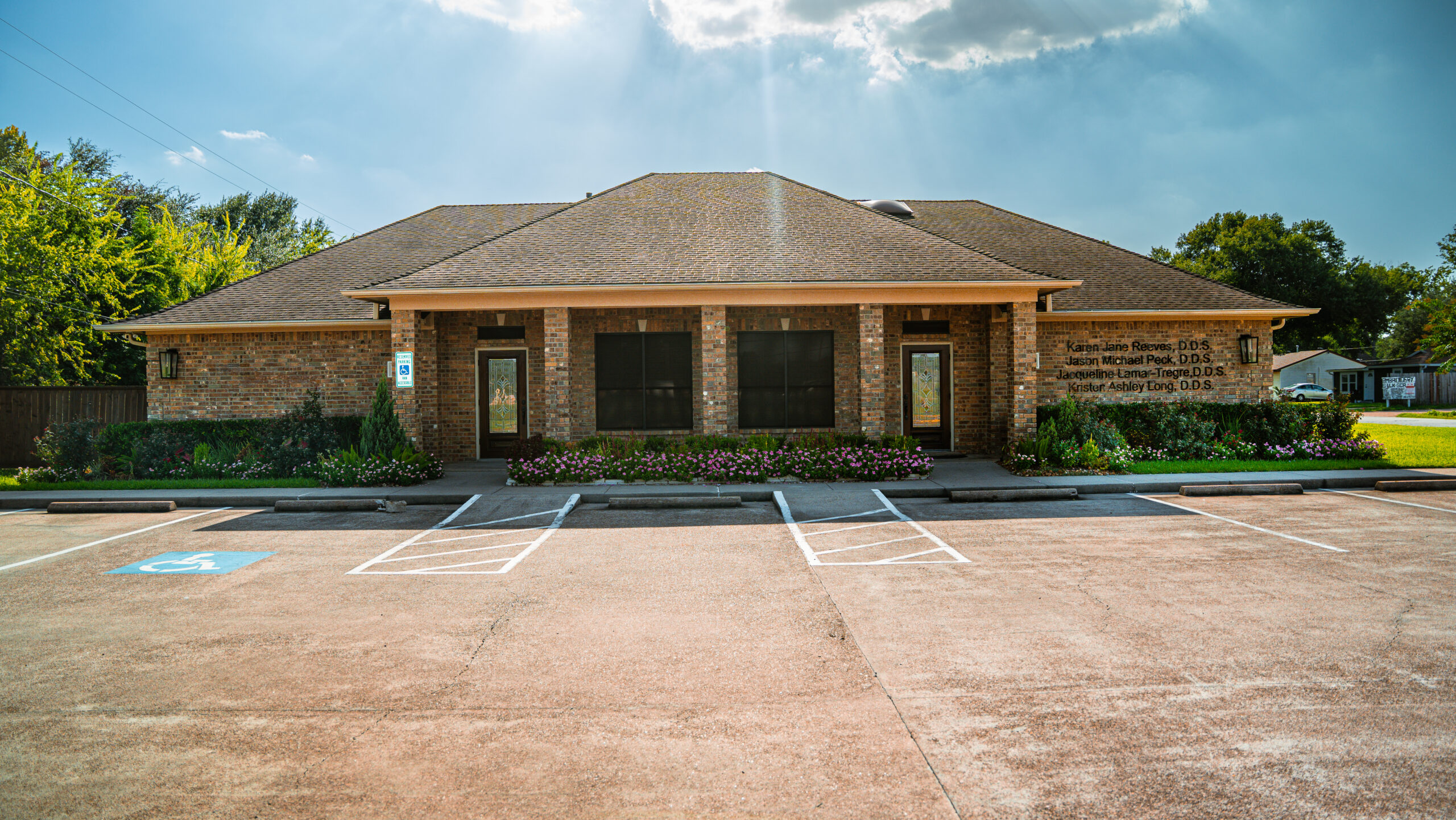 Exterior of the Deer Park Family Dentistry Exterior of the Deer Park Family Dentistry clinic showing a brick building with landscaped greenery and an empty parking lot under a blue sky with scattered clouds – Deer Park Family Dentistry